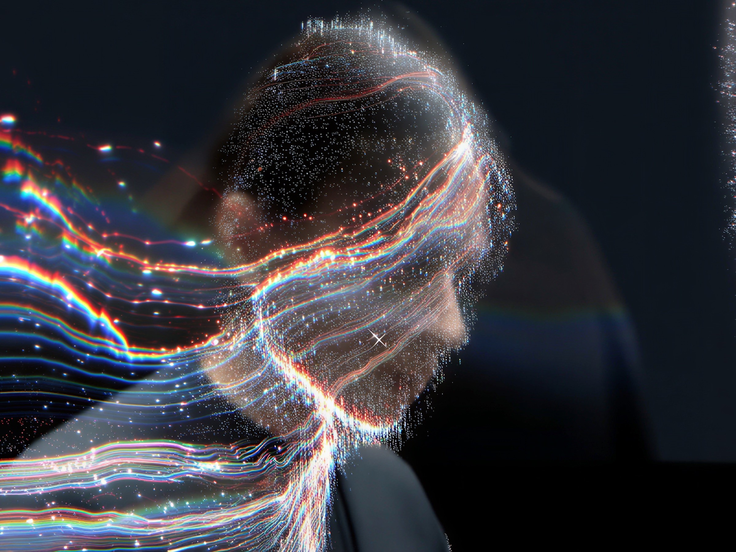 A figure made of flowing streaks of colored light on a dark background.