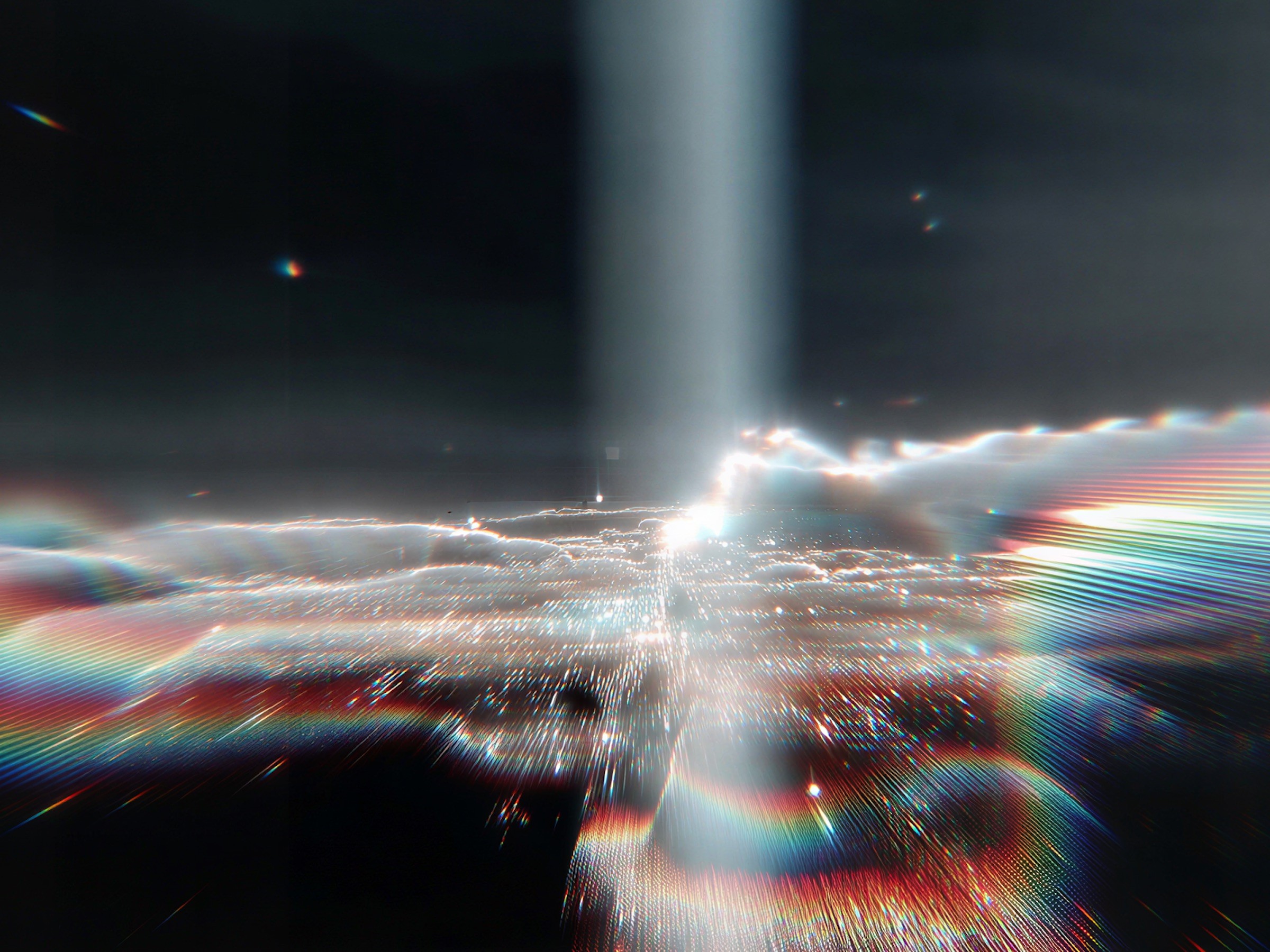 A beam of light splitting into rainbow streaks in a dark space.